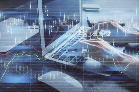 Double exposure of woman hands typing on computer and forex chart hologram drawing. Stock market...