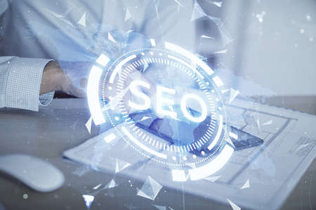 Multi exposure of mans hands holding and using a digital device and seo drawing. search optimization concept.の写真素材