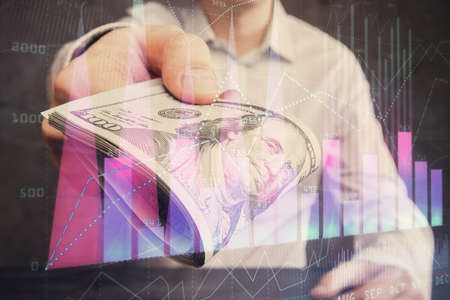 Multi exposure of financial graph drawing hologram and USA dollars bills and man hands. Analysis concept.の写真素材