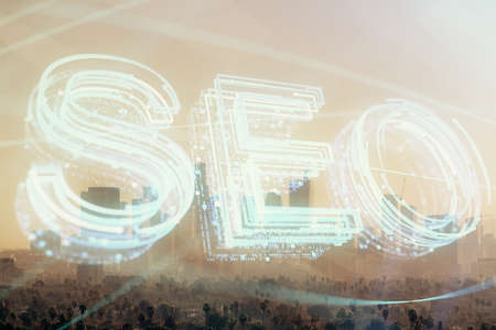 SEO hologram on city view with skyscrapers background double exposure. Search optimization concept.の写真素材