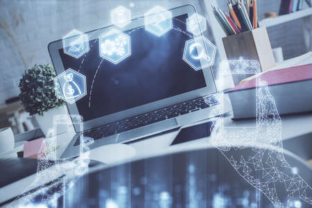 Computer on desktop in office with technology theme hologram. Double exposure. Tech concept.の写真素材