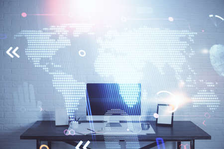 Double exposure of desktop with computer and world map hologram. International data network concept.