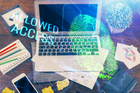 Computer on desktop in office with finger print drawing. Double exposure. Concept of business data security.の写真素材