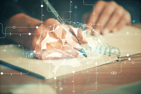 Multi exposure of writing hand on background with brain hologram. Concept of learning.