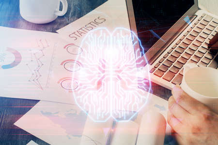 Businessman with computer background with brain theme hologram. Concept of brainstorm. Multi...