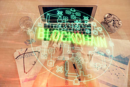 Double exposure of woman hands working on computer and blockchain theme hologram drawing. Top View....