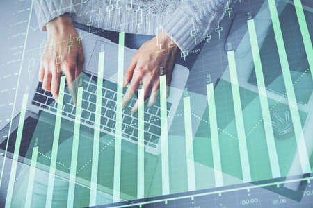 Multi exposure of woman hands working on computer and forex chart hologram drawing. Top View....