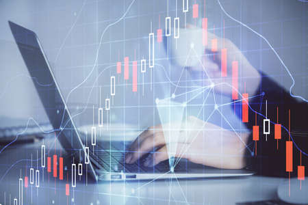 Double exposure of businesswoman hands typing on computer and forex graph hologram drawing....