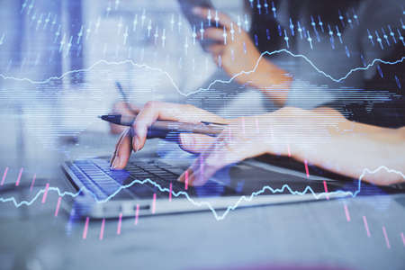 Multi exposure of woman hands typing on computer and financial graph hologram drawing. Stock market...