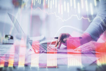 Double exposure of woman hands typing on computer and forex chart hologram drawing. Stock market...