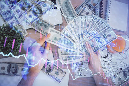 Multi exposure of financial graph drawing hologram and USA dollars bills and man hands. Analysis concept.の写真素材