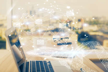 Desktop computer background in office and flying envelops hologram drawing. Double exposure....