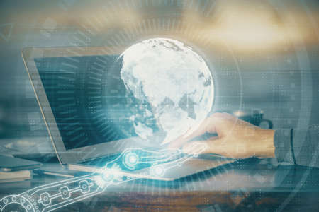 Multi exposure of world map hologram with man working on computer on background. Concept of...