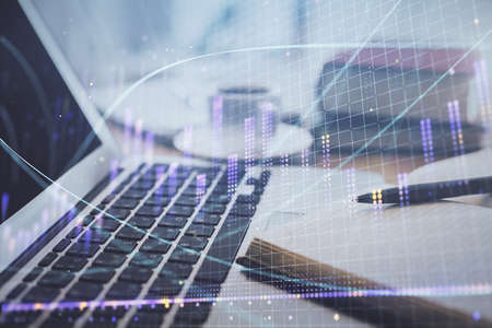 Double exposure of financial chart drawing and desktop with coffee and items on table background. Concept of forex market tradingの写真素材