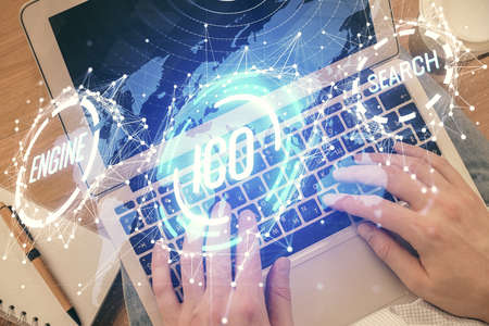 Double exposure of mans hands typing over computer keyboard and crypto currency theme hologram drawing. Top view. Blockchain concept.の写真素材