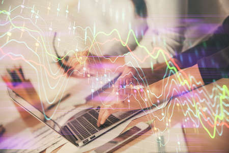 Multi exposure of woman hands typing on computer and financial chart hologram drawing. Stock market...