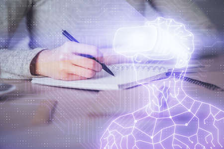 AR hologram over hands taking notes background. Concept of augmented reality. Double exposureの写真素材