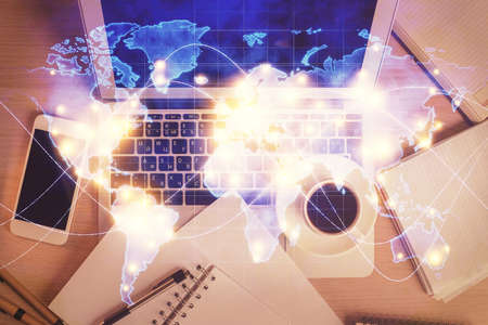 Business theme hologram drawings over computer on the desktop background. Top view. Multi exposure....