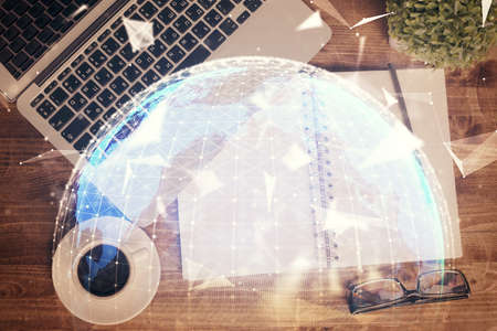 Business theme hologram drawings over computer on the desktop background. Top view. Multi exposure. Concept of international connections.の写真素材
