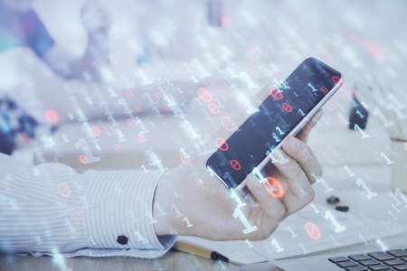 Double exposure of mans hand holding and using a digital device and data theme hologram drawing....