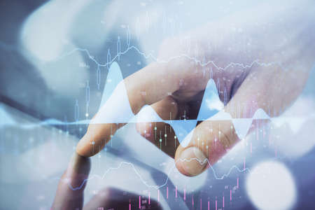 Multi exposure of mans hands holding and using a phone and financial chart drawing. Market analysis...