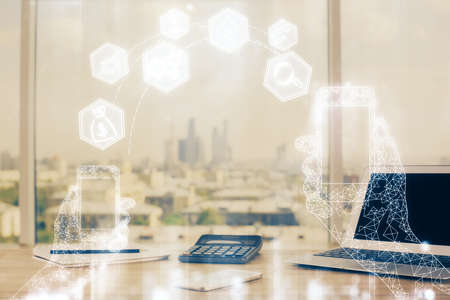 Computer on desktop in office with technology theme hologram. Multi exposure. Tech concept.
