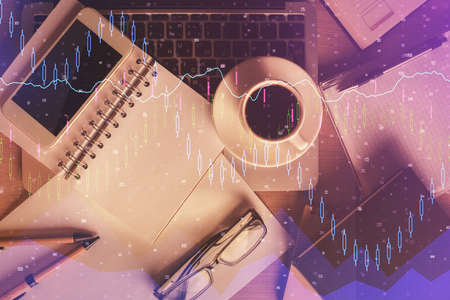 Double exposure of forex chart hologram over desktop with phone. Top view. Mobile trade platform...