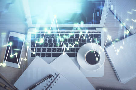 Stock market chart and top view computer on the table background. Double exposure. Concept of...