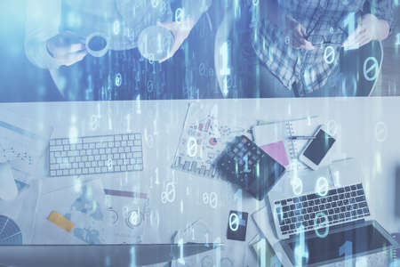 Double exposure of man and woman working together and data theme hologram drawing. Computer...