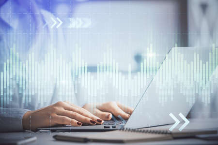 Double exposure of woman hands working on computer and forex graph hologram drawing. Financial...