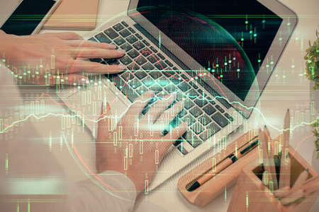 Multi exposure of woman hands typing on computer and forex chart hologram drawing. Stock market...