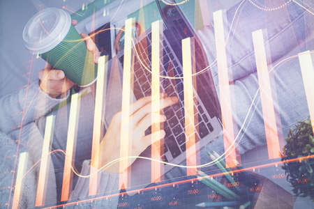 Double exposure of woman hands typing on computer and forex chart hologram drawing. Stock market...
