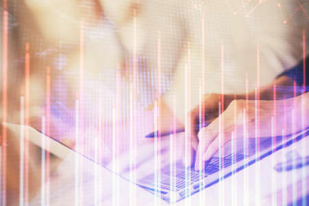 Double exposure of woman hands typing on computer and forex chart hologram drawing. Stock market...