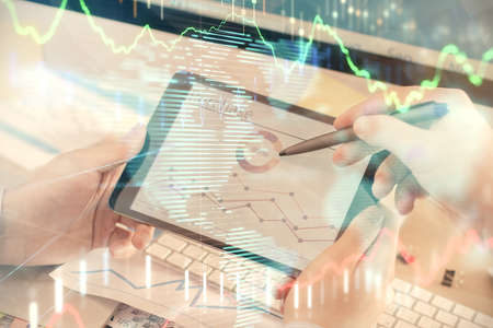 Double exposure of mans hands holding and using a phone and financial chart drawing. Market analysis...