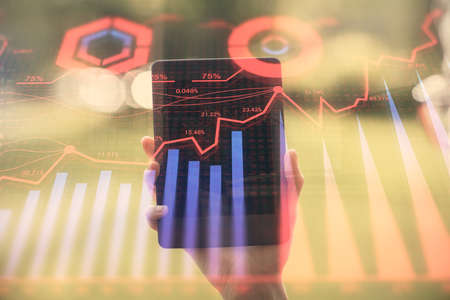 Double exposure of forex chart sketch hologram and woman holding and using a mobile device....