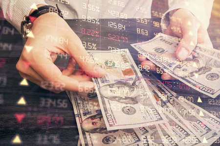Multi exposure of financial graph drawing hologram and USA dollars bills and man hands. Analysis...
