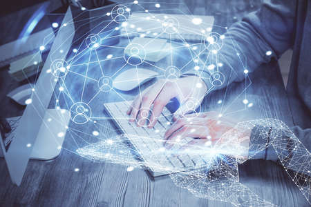 Social network theme hologram with businessman working on computer on background. Concept of world...