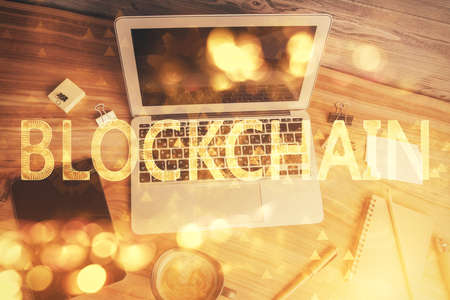 Blockchain theme hologram drawings over computer on the desktop background. Top view. Multi exposure. Concept of cryptoeconomy.の写真素材