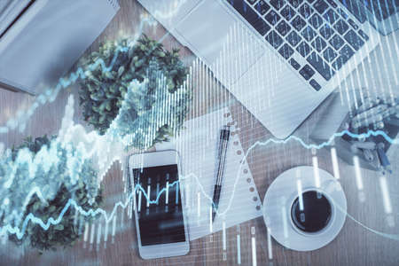 Multi exposure of financial chart hologram over desktop with phone. Top view. Mobile trade platform concept.の写真素材