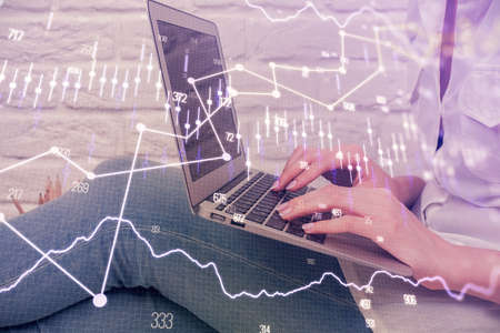 Multi exposure of woman hands typing on computer and forex chart hologram drawing. Stock market...