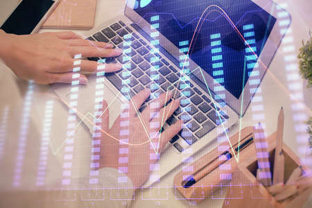 Multi exposure of woman hands typing on computer and forex chart hologram drawing. Stock market...