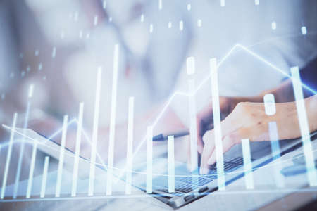 Double exposure of woman hands typing on computer and forex chart hologram drawing. Stock market...