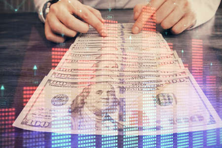 Multi exposure of forex graph drawing hologram and USA dollars bills and man hands. Technical Analysis concept.の写真素材