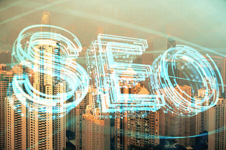 SEO hologram on city view with skyscrapers background double exposure. Search optimization concept.