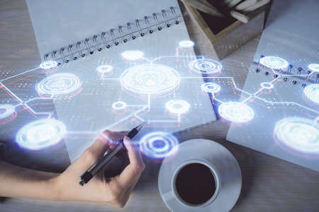 Social network theme hologram over hands taking notes background. Concept of global international...