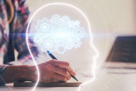 Multi exposure of womans writing hand on background with brain hud. Concept of learning.