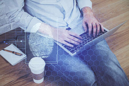 Fingerprint hologram with businessman working on computer on background. Security concept. Double exposure.の写真素材