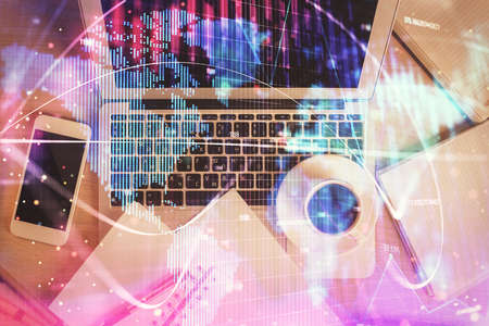 Business theme hologram drawings over computer on the desktop background. Top view. Multi exposure....
