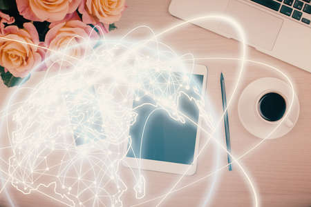 Double exposure of business theme hologram over desktop with phone. Top view. Mobile international...
