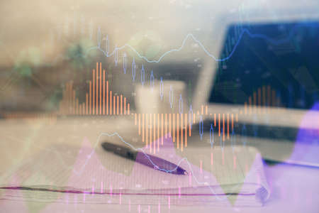 Double exposure of financial graph drawings and desk with open notebook background. Concept of forex...